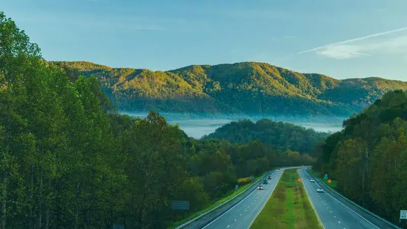 A country road traveling through misty, forested mountains in Southwest Virginia